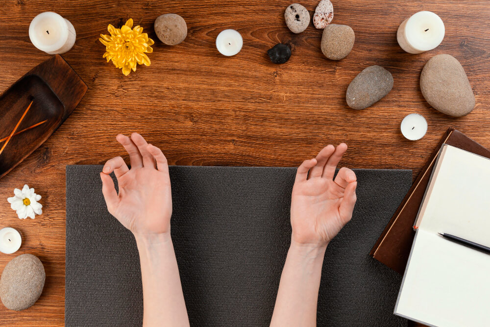 Mani alzate di una donna seduta su un tappetino da yoga