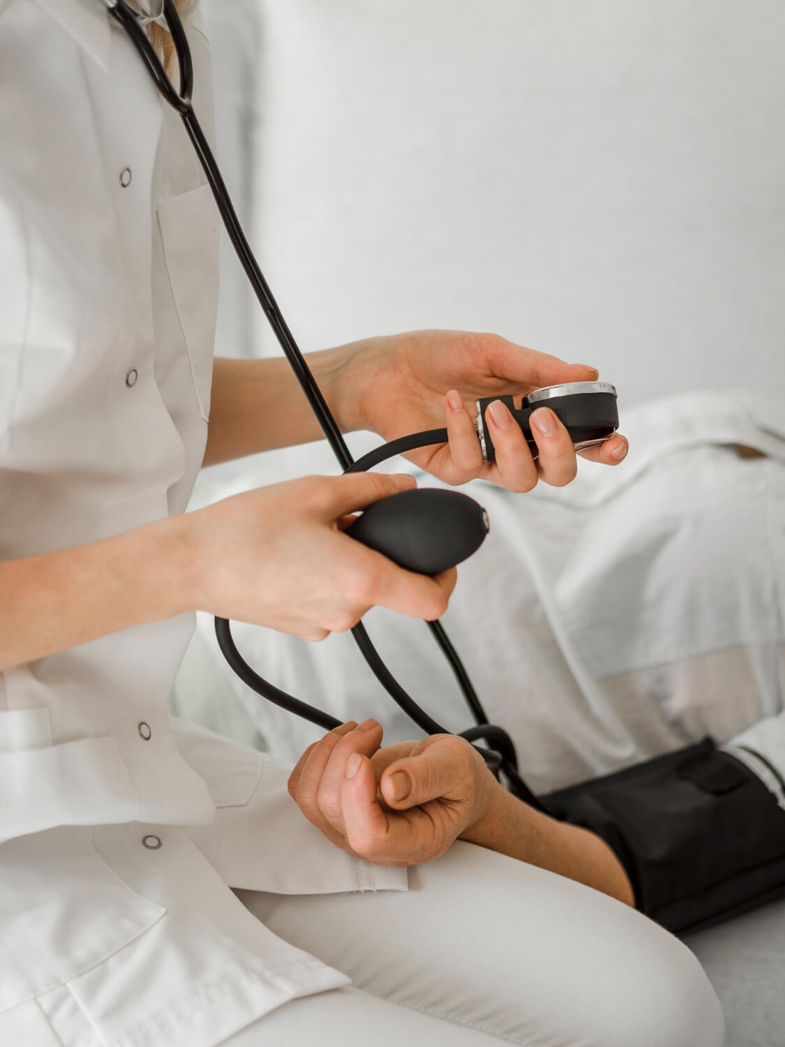 un operatrice sanitaria misura la pressione arteriosa ad un paziente.