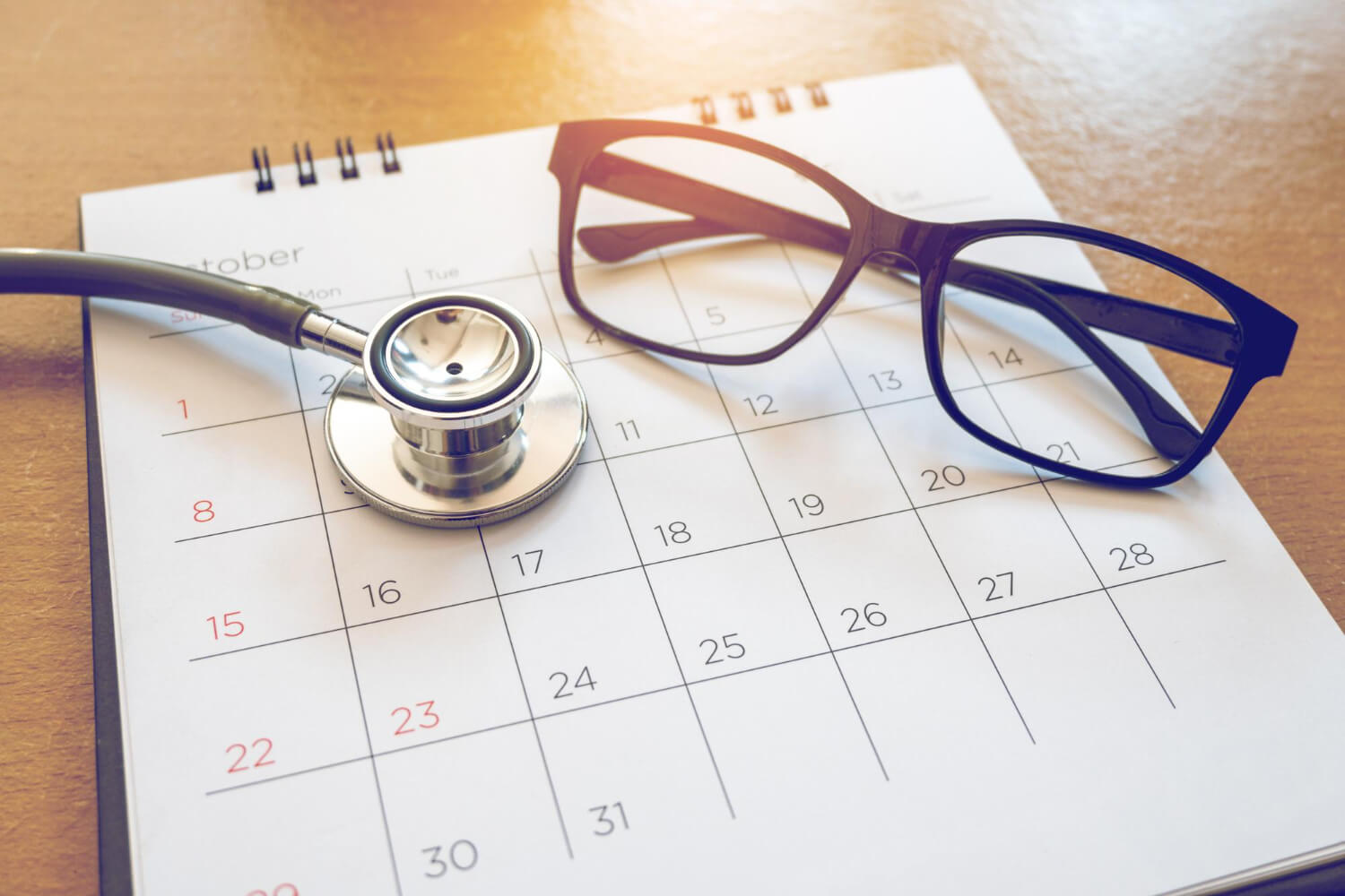 Calendario di ottobre con stetoscopio e occhiali: promemoria per il check up annuale